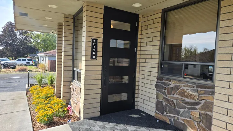 The Suite B entrance: a black door under the covered entry, beside a Suite B sign
